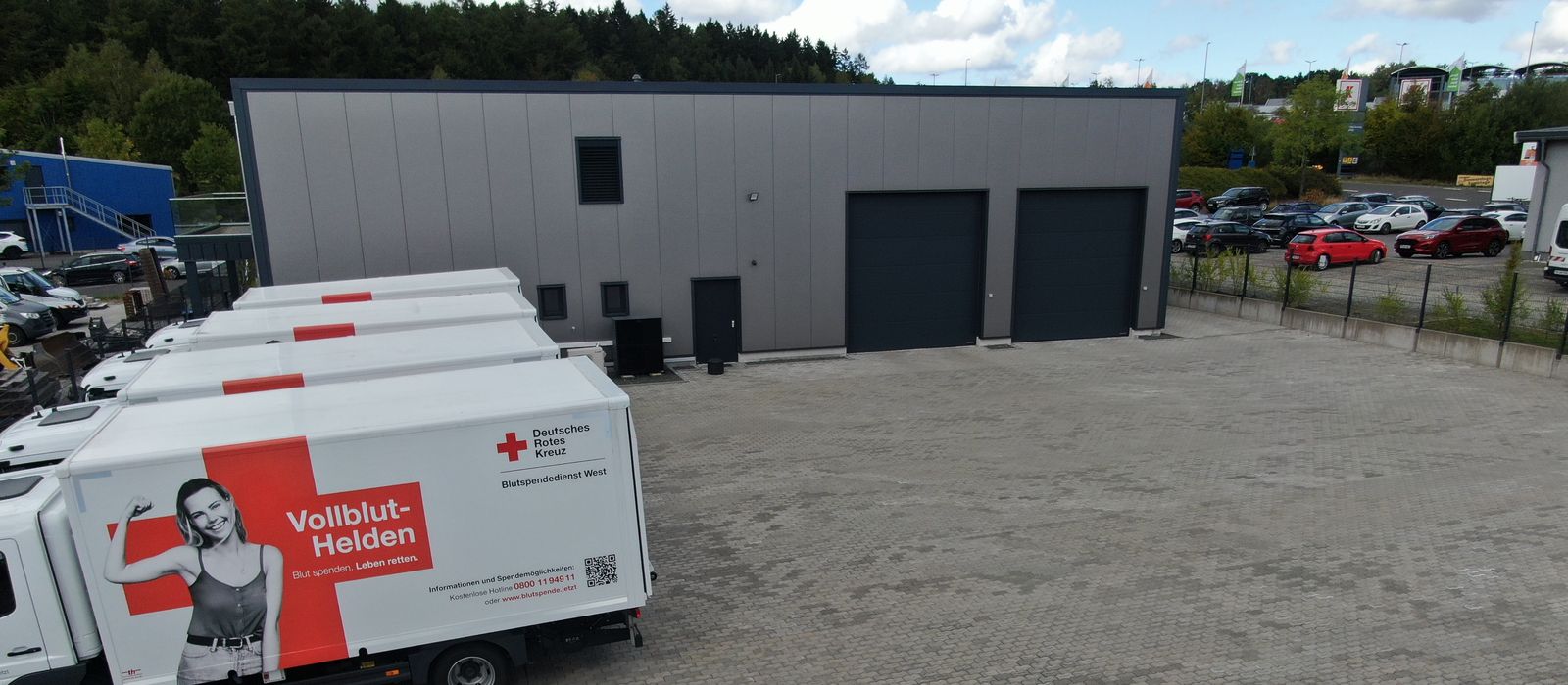 Blutspendefahrzeuge des DRK auf der Hoffläche vor dem Gebäude